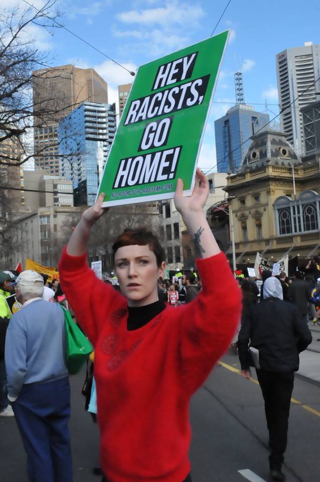 Placard says: Hey Racists, Go Home.
