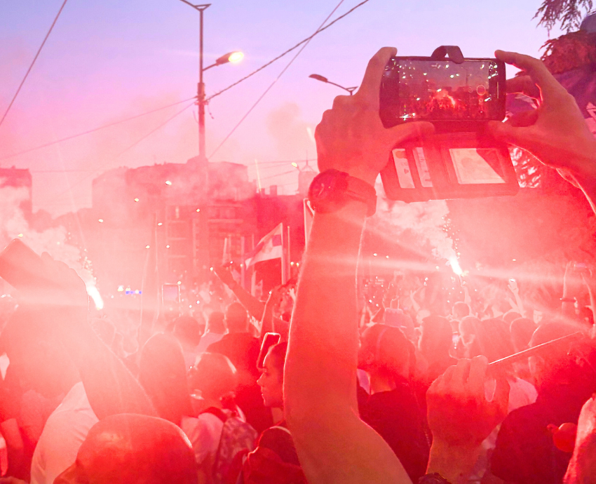 crowds of protesters in a square in Belgrade