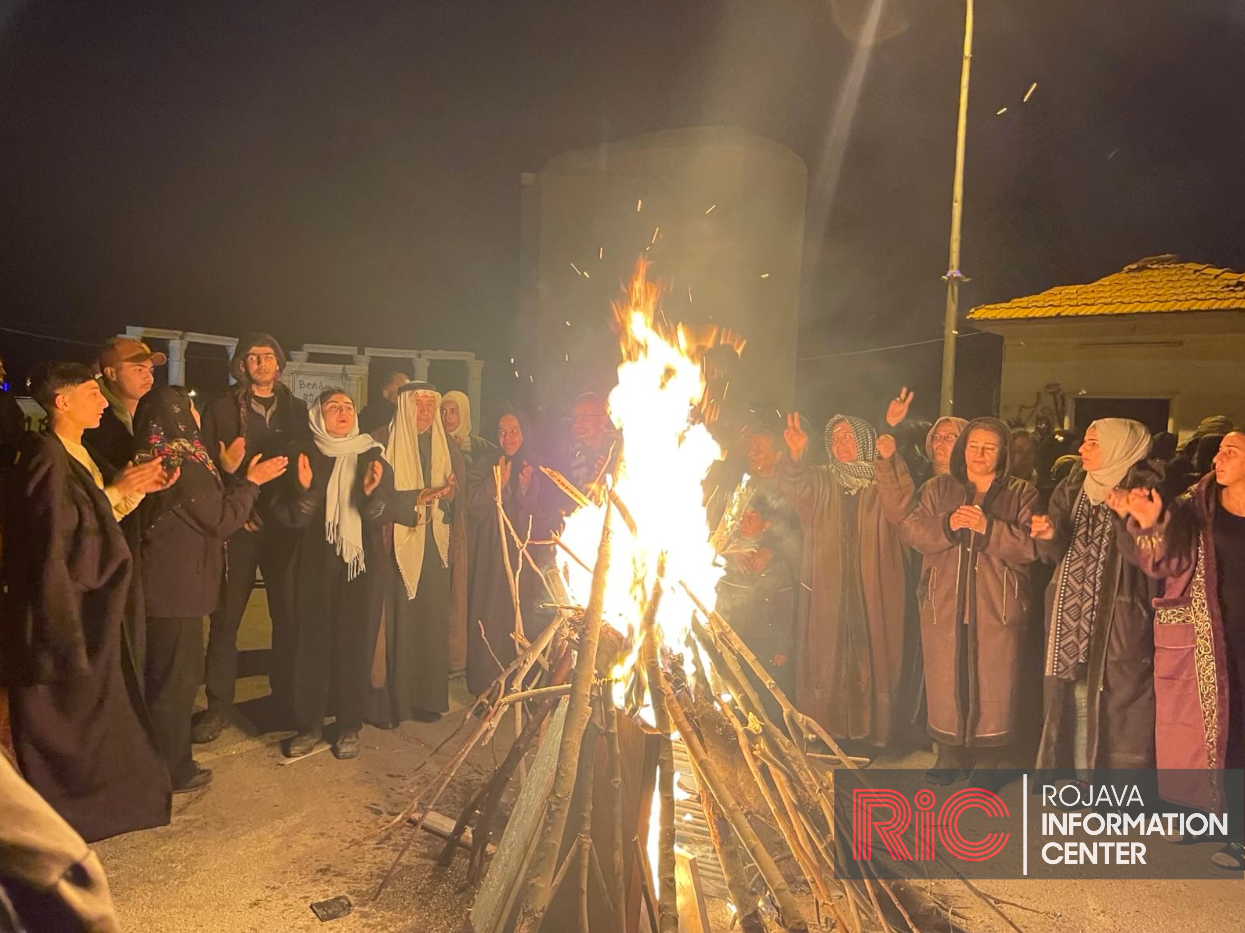 People around a bonfire at Tishreen dam