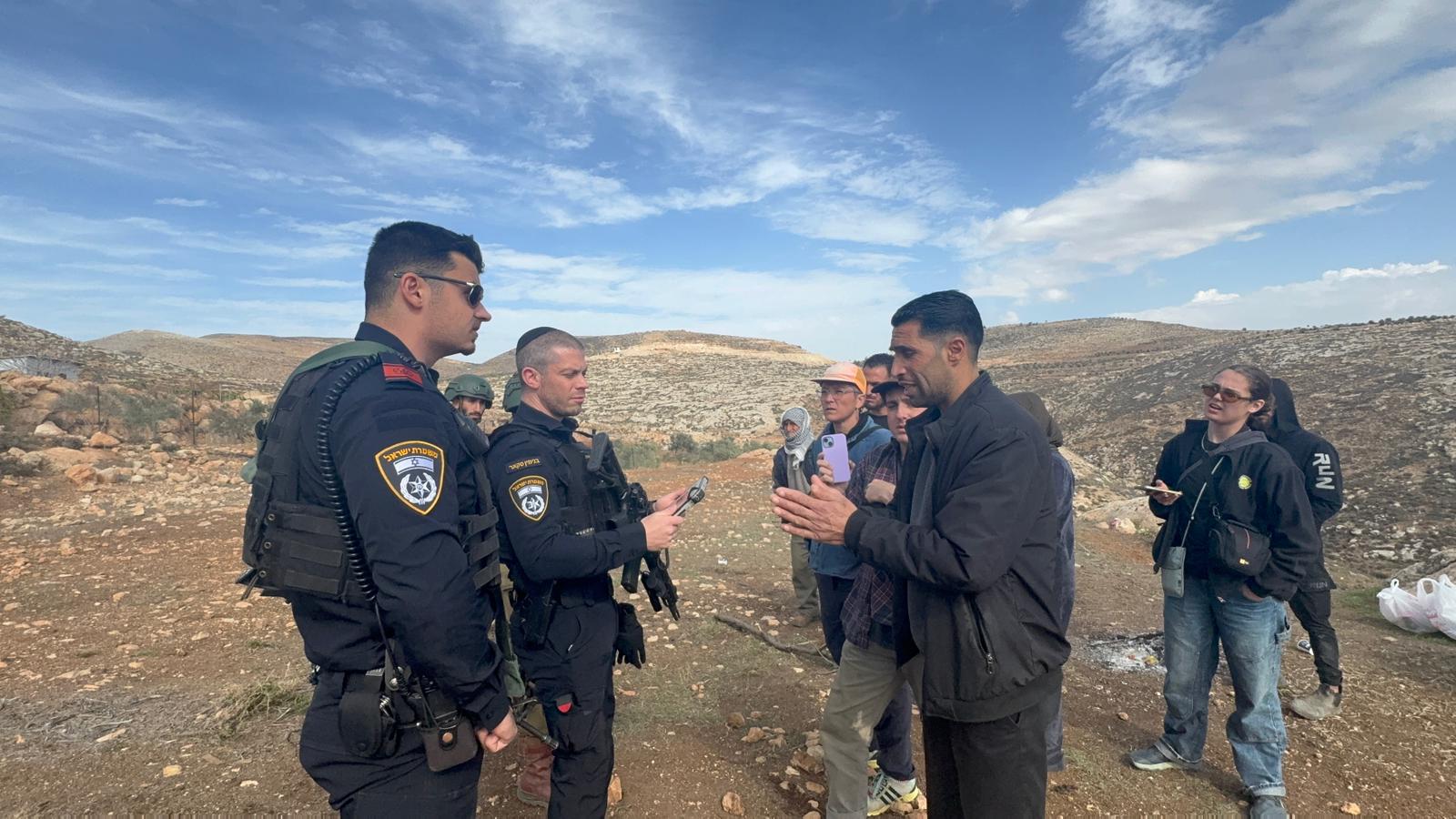 Israeli soldiers and police with Palestinian villagers and ISM witnesses