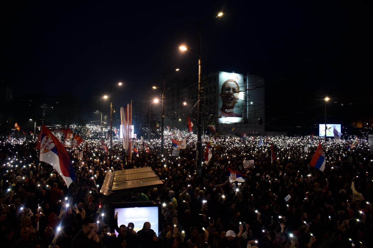 People holding mobile phone torches at a mass vigil