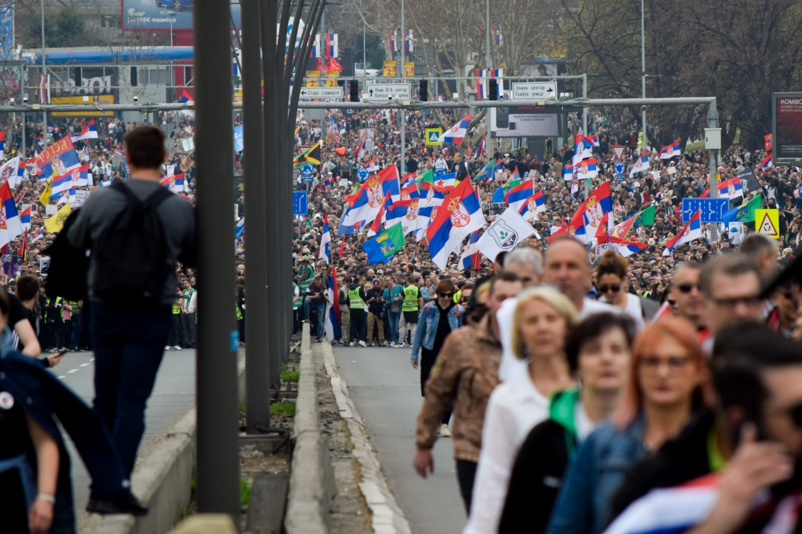 Protesters march down the highway, waving flags 