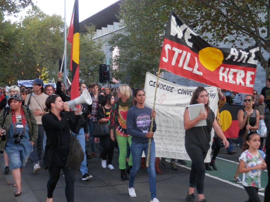 Protesters marching, chanting and holding banners and placards.