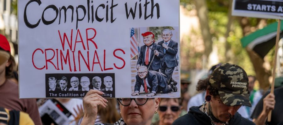 sign from a protest in Sydney against the war on Iran reading: 'complicit with war criminals'
