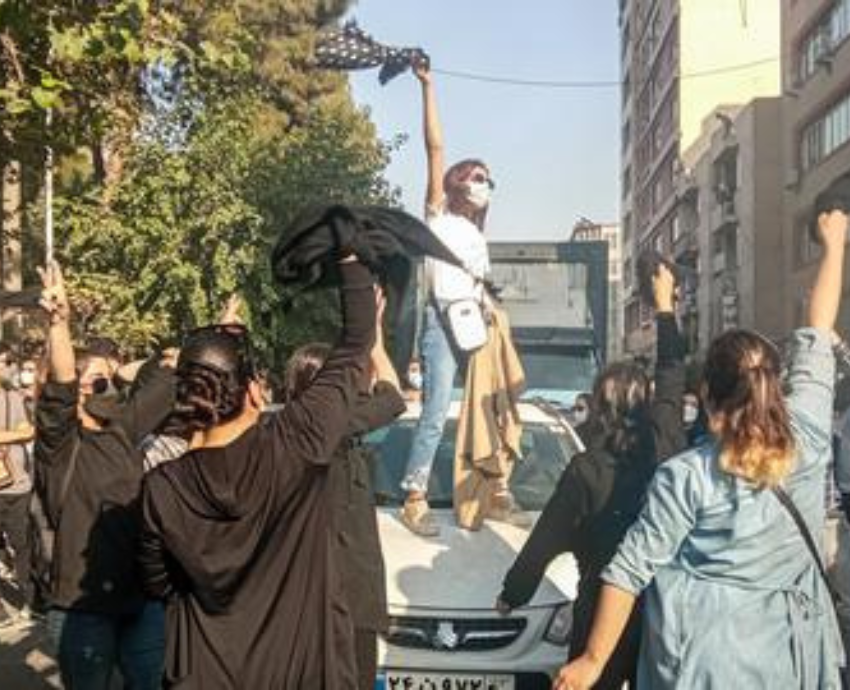 women standing on cars protesting