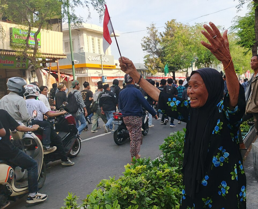 woman cheers on protesters in Indonesia