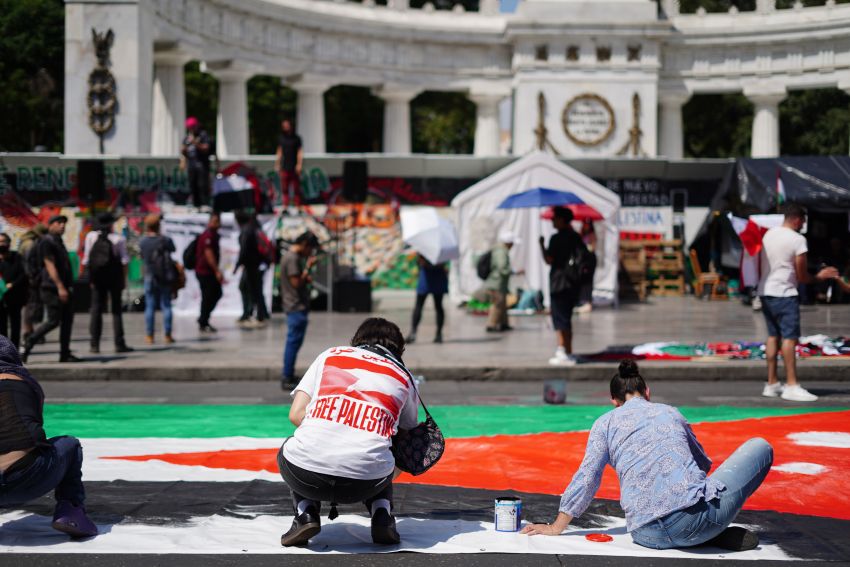 protesters in a city square with a banner