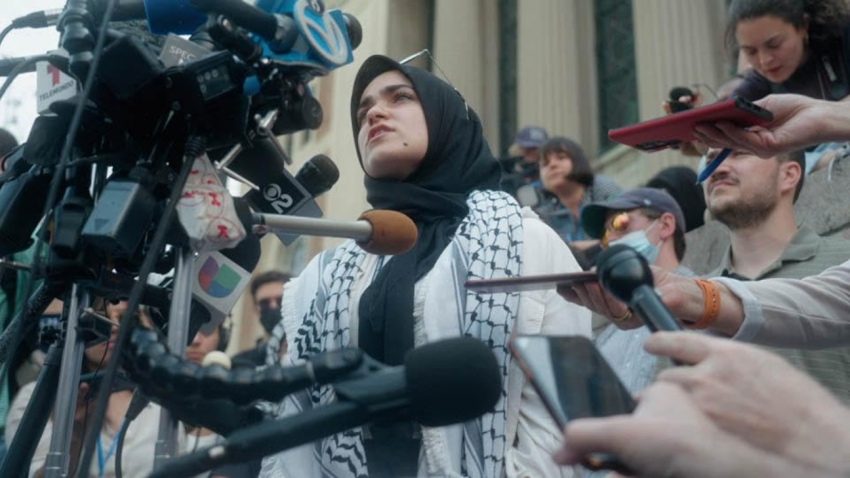 A woman in a hijab addresses the media