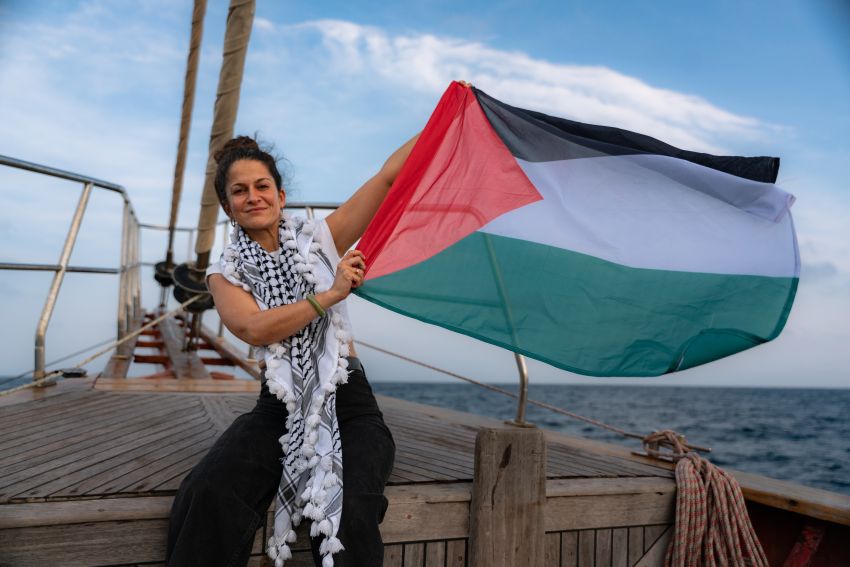 Woman holds palestinian flag onboard a boat