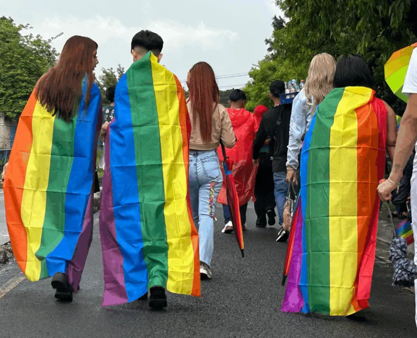 People with rainbow flags as capes