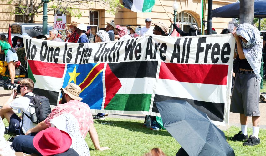 A banner which reads 'no one is free until we are all free'