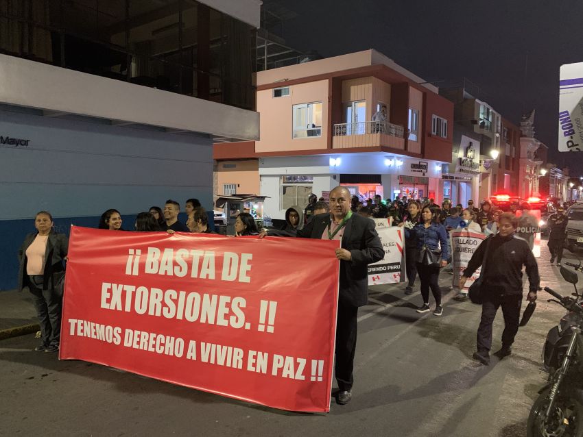 Protesters with a banner that reads: 'No more extortion. We have a right to live in peace.'