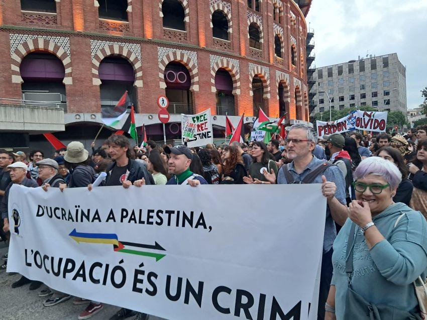 protesters marching with a banner that reads: 'From Ukraine to Palestine: Occupation is a crime"