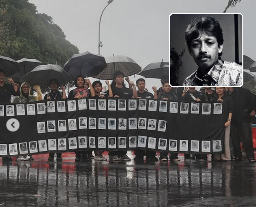 People standing in the rain protesting with a banner and umbrellas