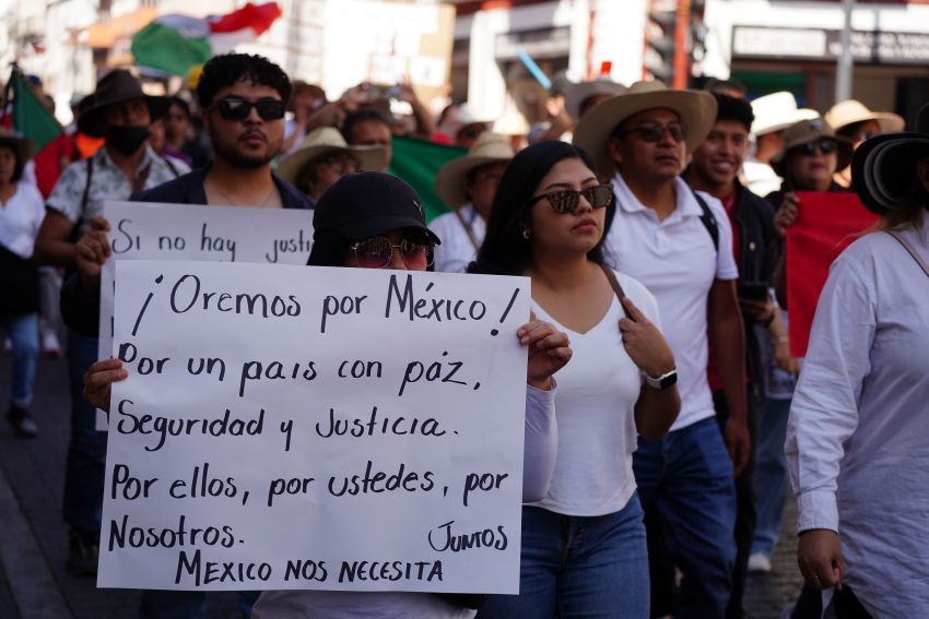 Protesters, with one carrying a sign