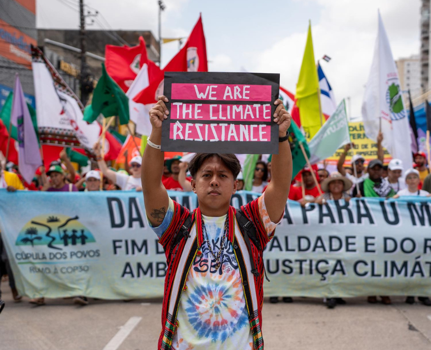 Protesters with banner and signs at COP30