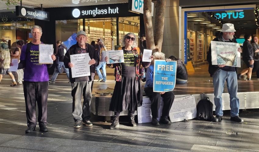 Supporters of the Adelaide Vigil for Manus and Nauru in Rundle Mall holding signs and placards supporting refugees.