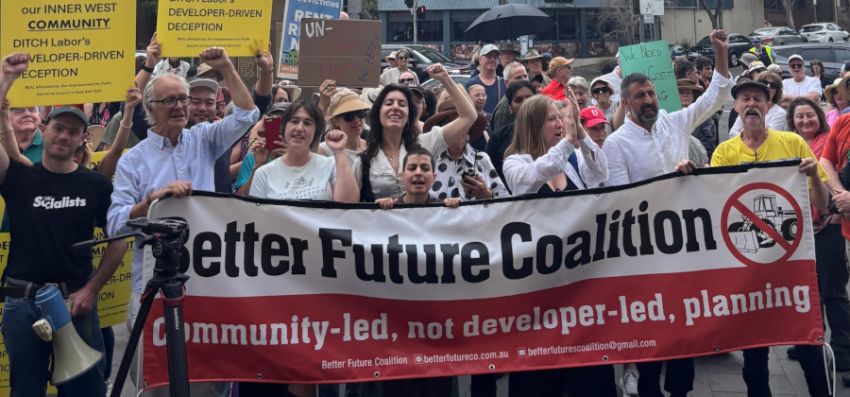 Housing rights protesters holding a Better Future Coaltion banner at a protest rally.