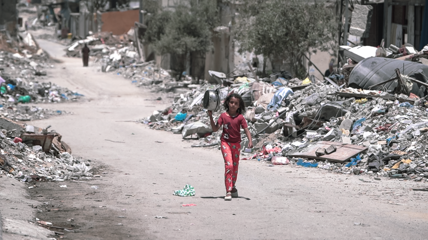 Young Palestinian girl walks along a road