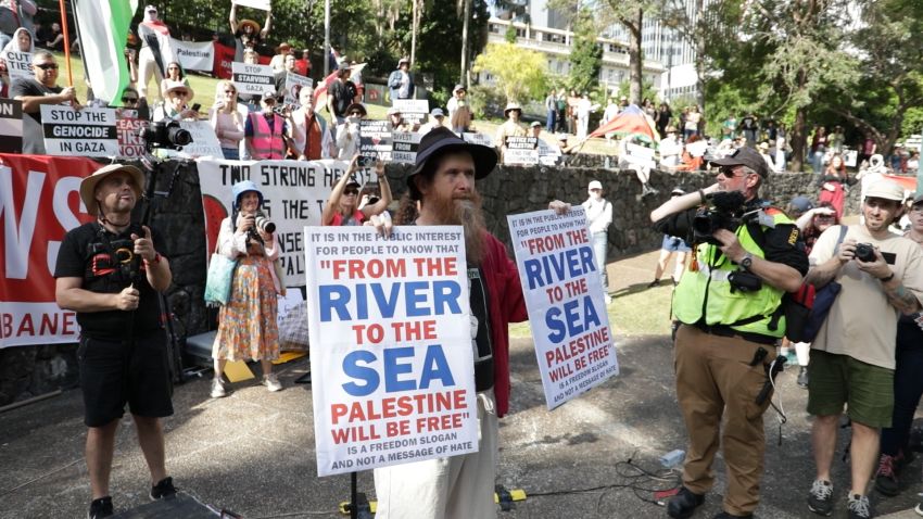 Alex Bainbridge holding signs shortly before being arrested, April 18