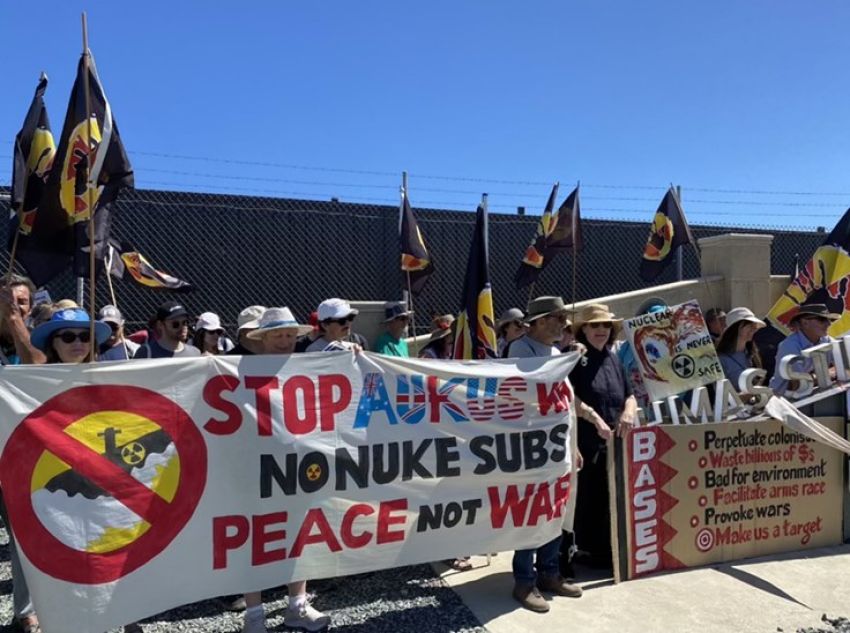 Protesters with banners and flags at an anti-AUKUS protest