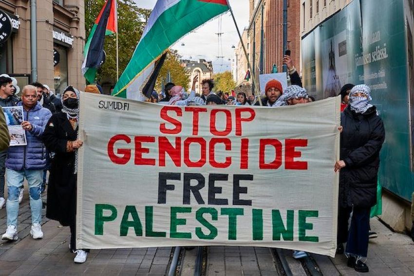Protesters holding a banner that says Stop Genocide, Free Palestine