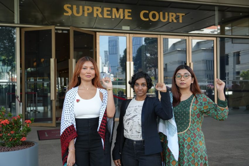 Three activists outside the Supreme Court