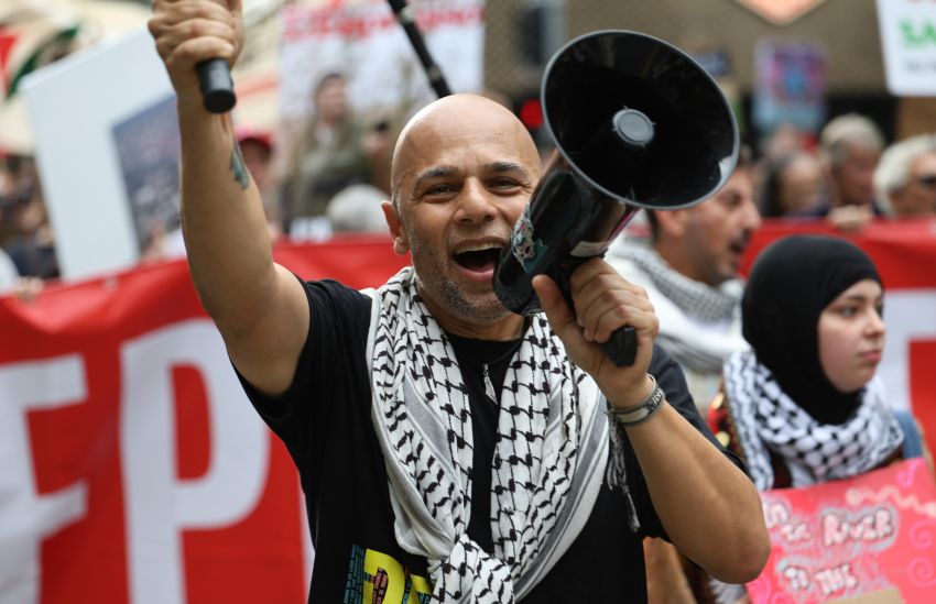 Palestinian activist Waddah Ali leading chants on the march