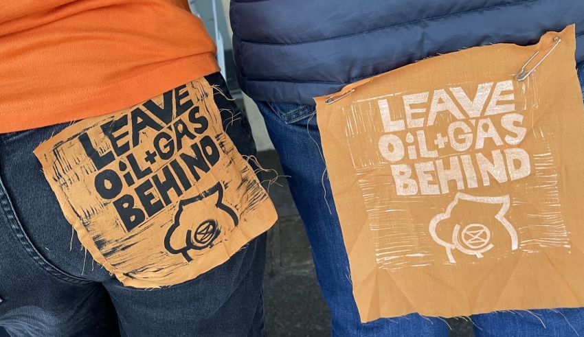 Leave Oil & Gas Behind patches on clothing of Dump Santos protesters