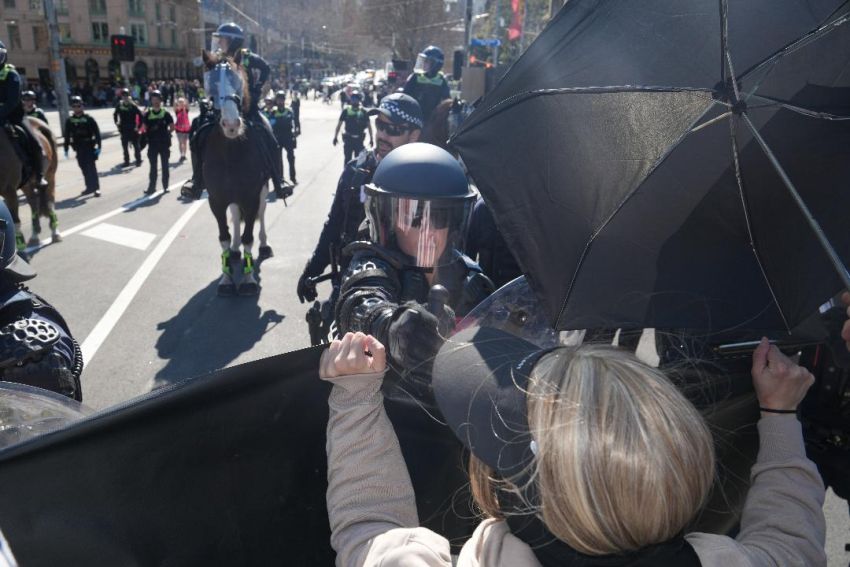 police officer sprays pepper spray at protesters