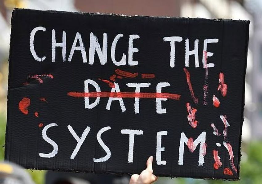 Hand painted sign that says Change the System
