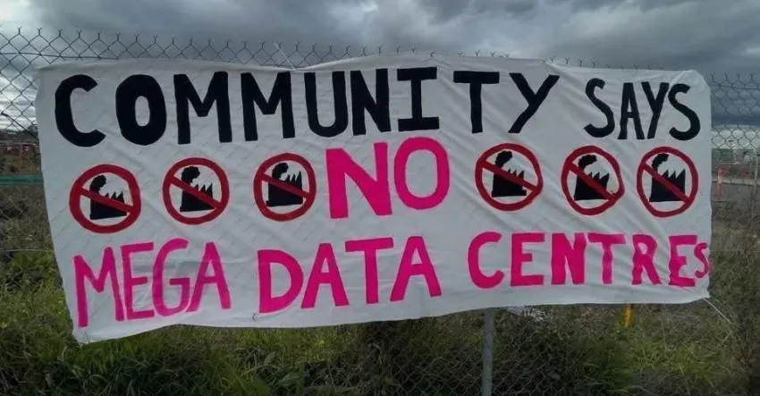 Photo of banner on a fence that reads Community Says NO to Mega Data Centres
