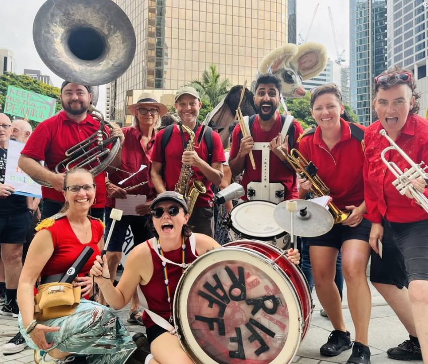 Group photo of rhe Riff Raff Radical Marching Band Magandjin/Brisbane crew in Magan-djin with thier instruments