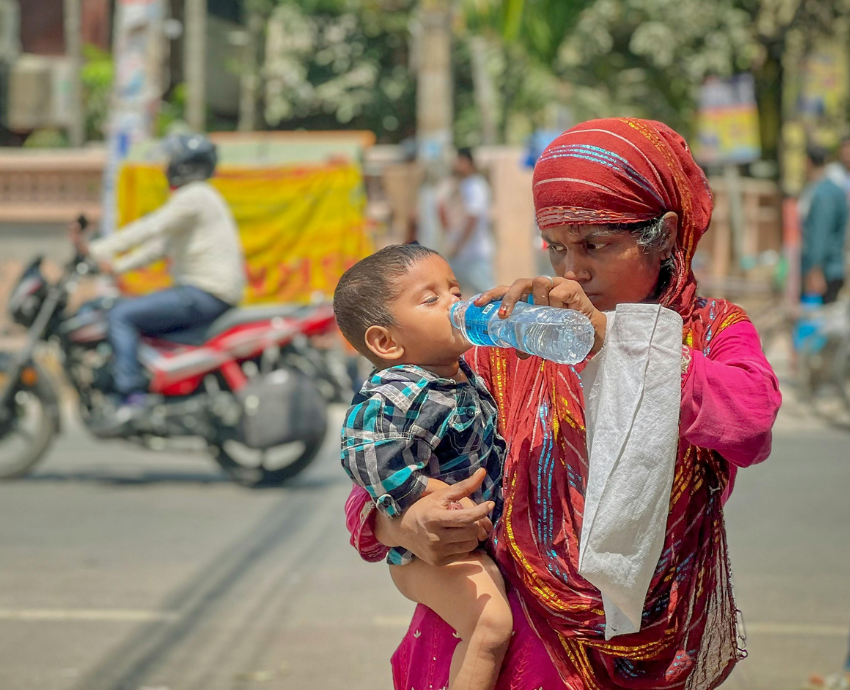 Woman giving water to a child
