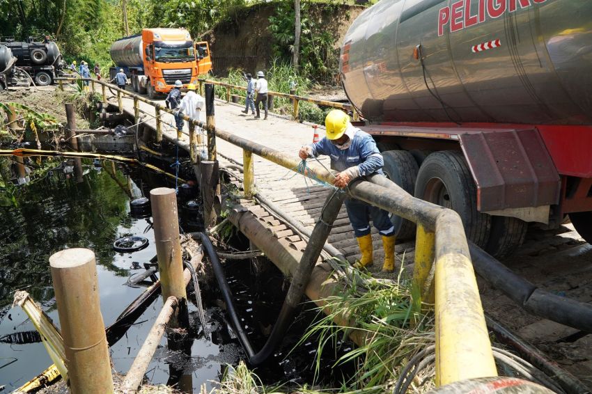 workers using vacuums to suck oil out of waterways in Ecuador