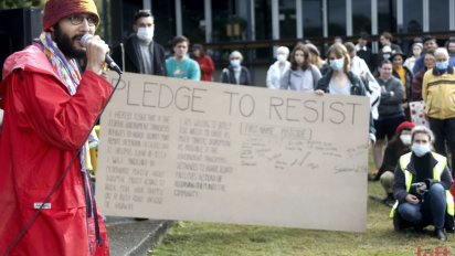 Greens coucillor Jonathan Sri encourages people to sign the pledge to resist