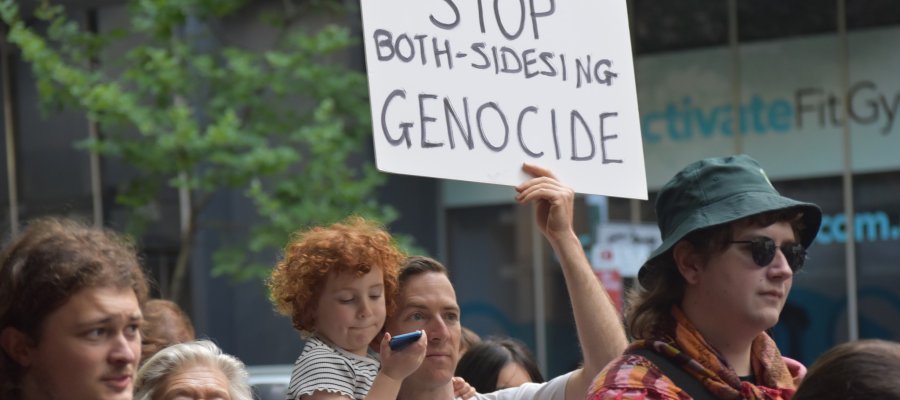 Protester holds sign that reads: stop both-sidesing genocide at ABC protest