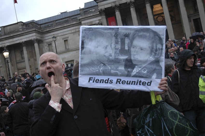 Protester holds a picture of Jimmy Savile and Margaret Thatcher