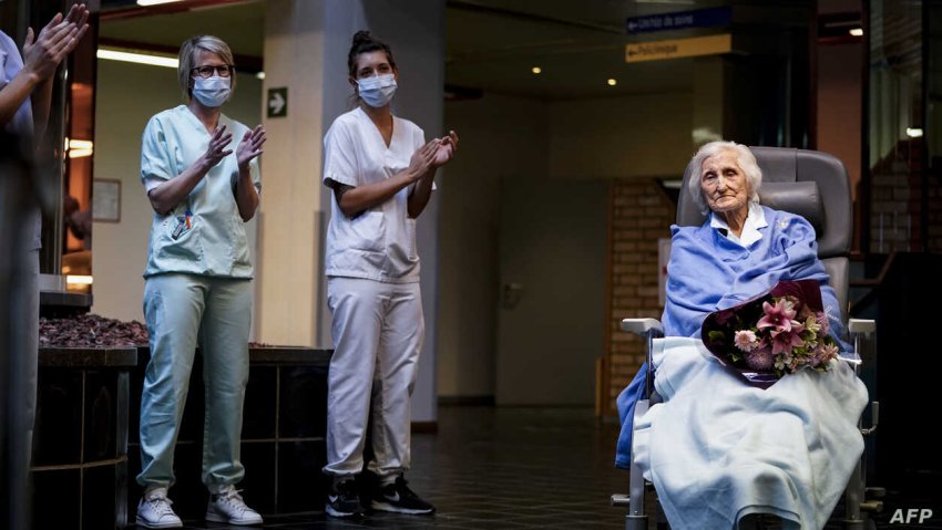 Belgian health workers salute 100-year-old COVID-19 survivor, Julia Dewilde as she leaves the Bois de l’Abbaye hospital (Credit: AFP)