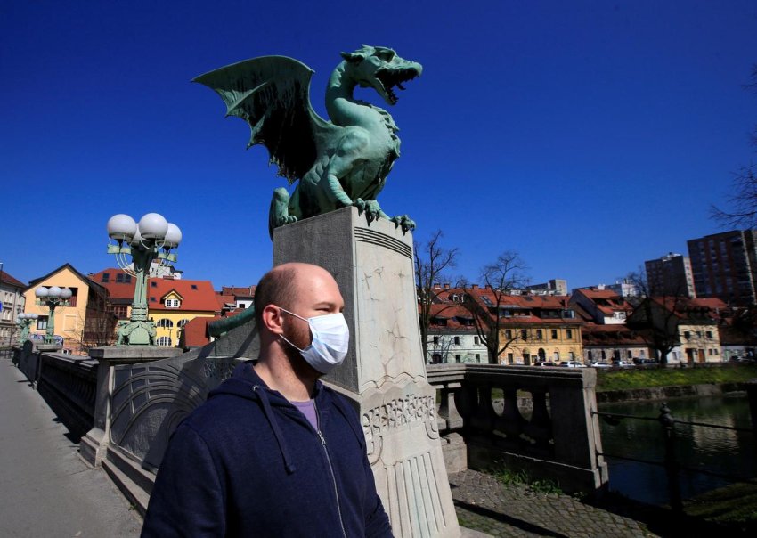  Ljubljana citizen with mask walks over the city's dragon bridge (Credit: Reuters)
