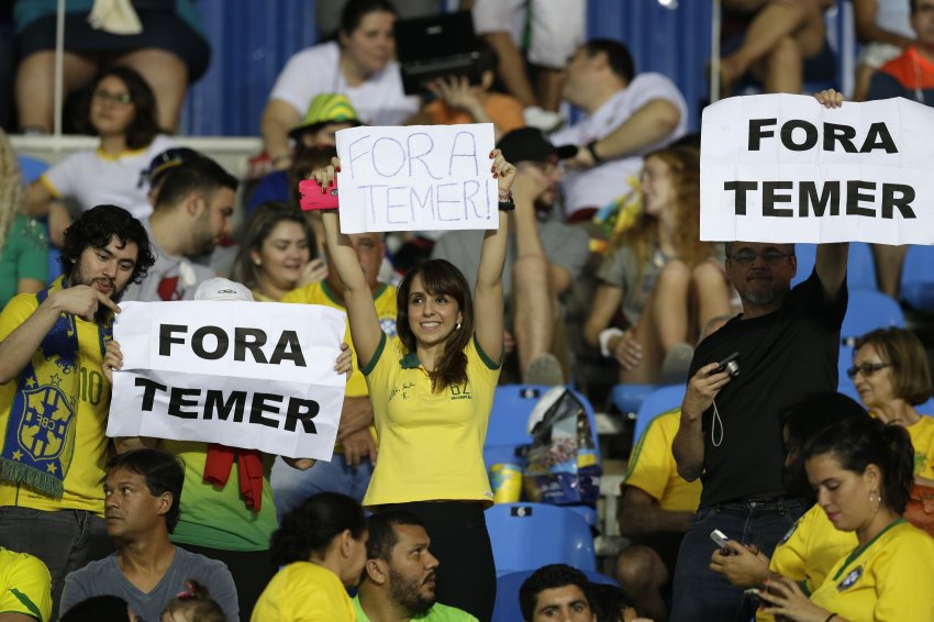 Fans hold “Fora Temer” signs