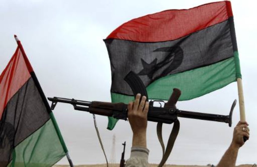Waving the Libyan flag.