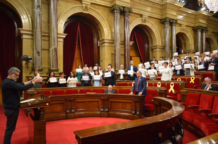 Catalan pro-sovereignty MPs (the parliamentary majority) show posters reading #freeAssange in Thursday's session. The motion of support was moved by CUP spokeperson Carles Riera (at the lectern)