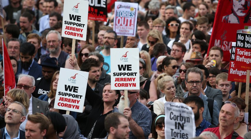 Protesters hold up a placards in support of Leader of the opposition Labour Party Jeremy Corbyn outside parliament during a pro-Corbyn demonstration in London in June last year.