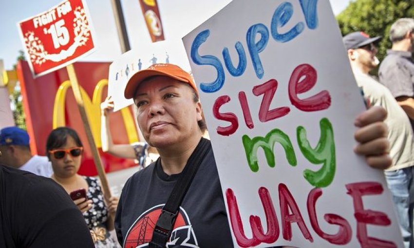 A protester demands raising the minimum wage.