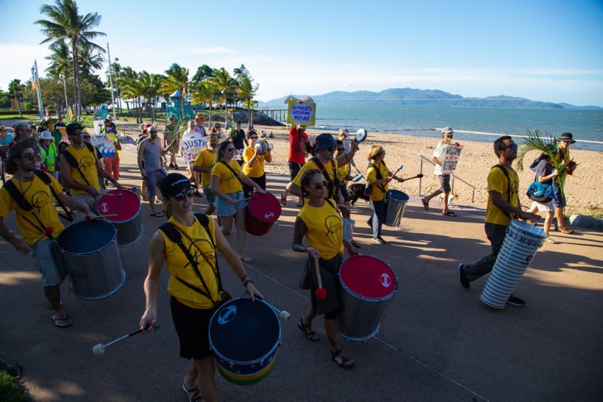 Townsville Drum Collective in full flight with Magnetic Island in the background. Photo: Amnesty Int