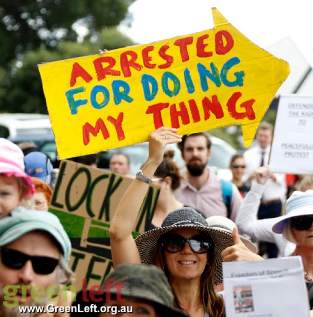 Protester with placard that says 'Arrested for doing my thing'