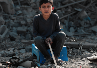 boy sits in rubble