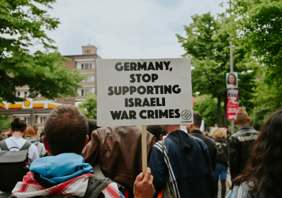 protester holding a sign saying 'Germany stop supporting Israel's war crimes'