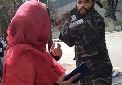 A member of the Taliban security forces threatens a protester in Kabul.